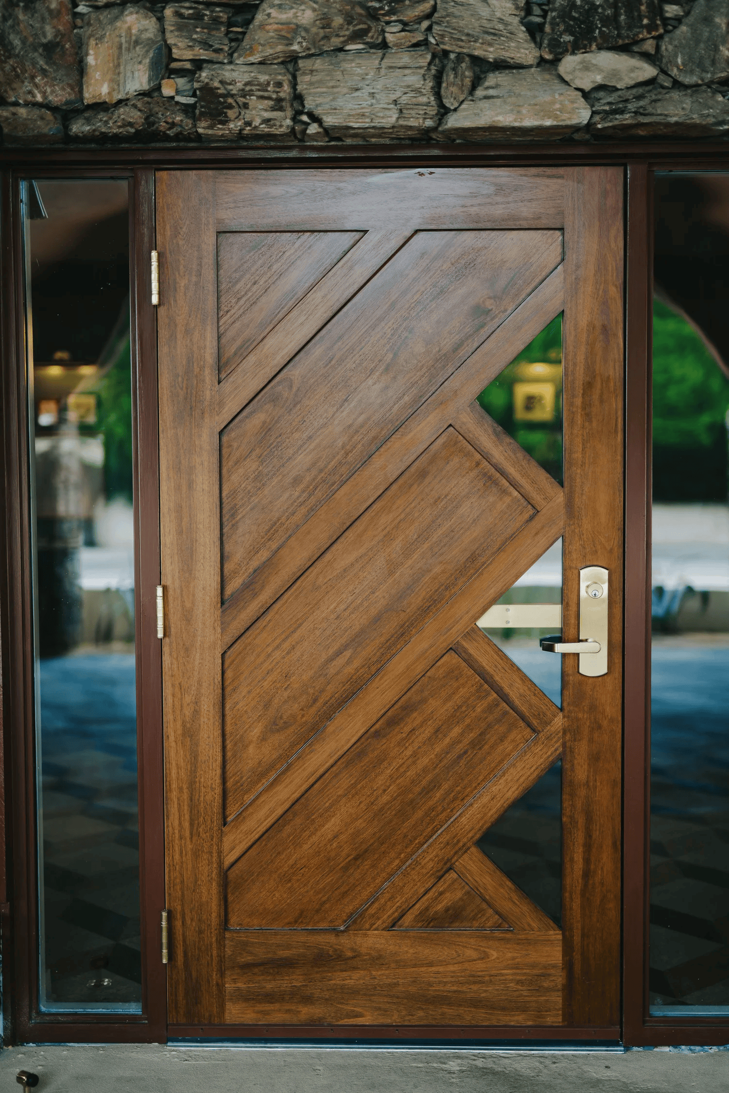 Full-color architectural photograph of a carved wooden front door framed in stone and glass