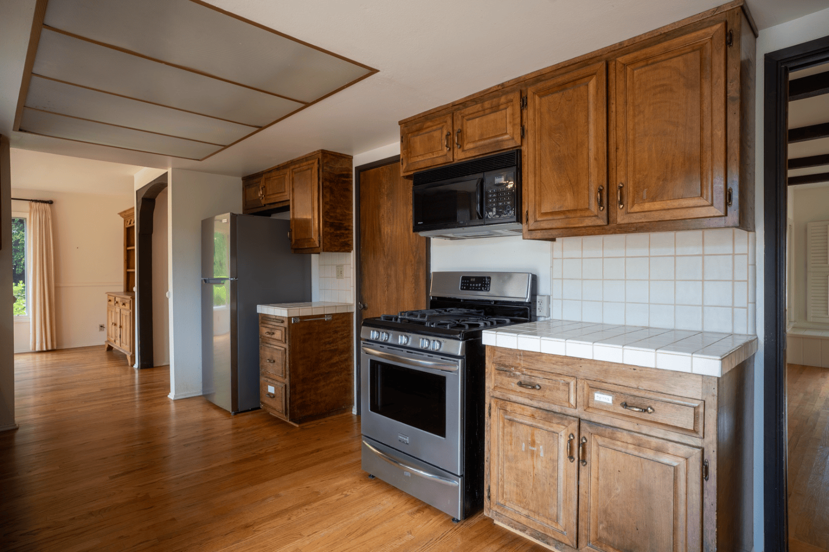 Kitchen with stainless range and leaded glass window over the sink, full-color interior photograph