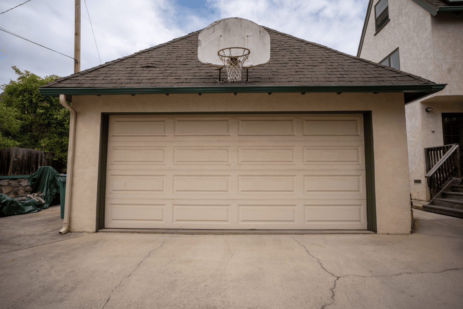 Straight-on view of the detached two-car garage with basketball hoop above the door, full-color architectural photograph
